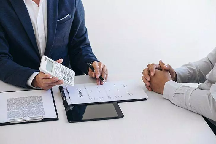 Agent showing customer cost of car hire insurance policy