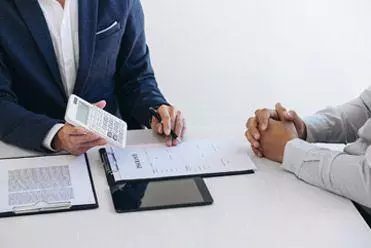 Agent showing customer cost of car hire insurance policy