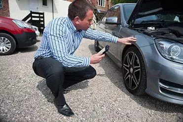 Businessman inspecting a rental car
