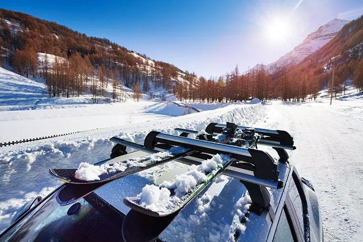 Car driving in snow with ski rack