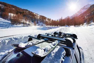 Car driving in snow with ski rack