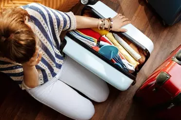 Lady stressing packing suitcase
