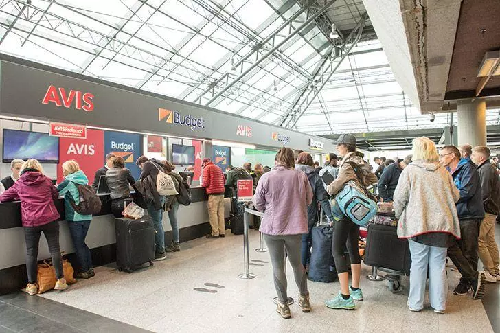 Travellers waiting in line at rental desk