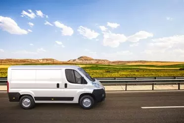 White van driving on road